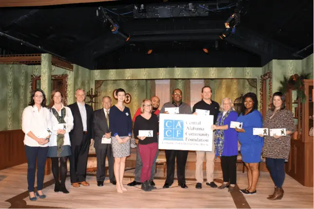 a group of people holding a CACF sign and grants for Arts and Community building