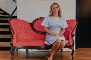 Dr. Jennifer Williams Stone seated on a couch smiling at the camera