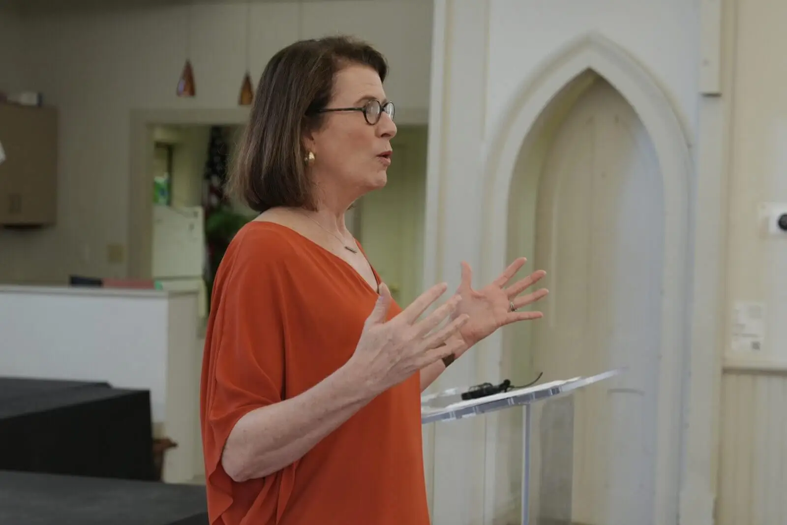 Woman standing next to a podium speaking