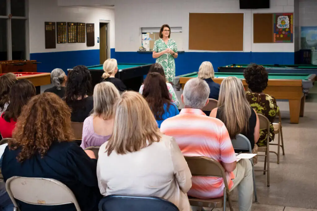 Burton speaking to a group of people in a recreation center