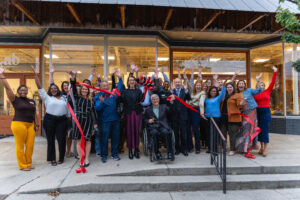 Group of people celebrating after cutting a ribbon for a new office for EACF