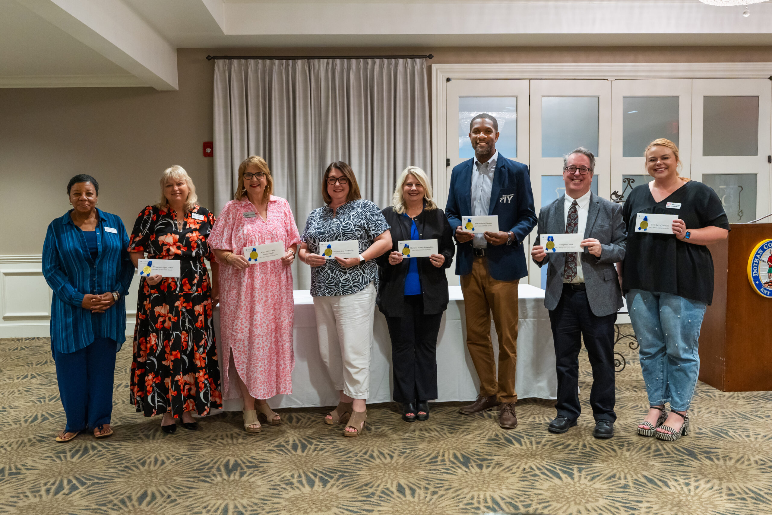 Nonprofit leaders standing holding their grant checks awarded by SACF